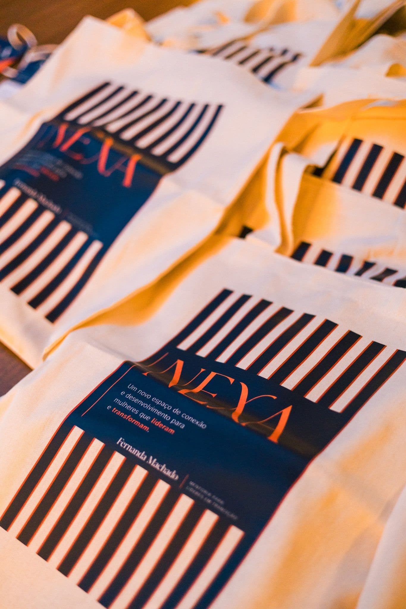 Sacolas de algodão do kit de boas-vindas, estampadas com listras azul-marinho e a marca NEXA.